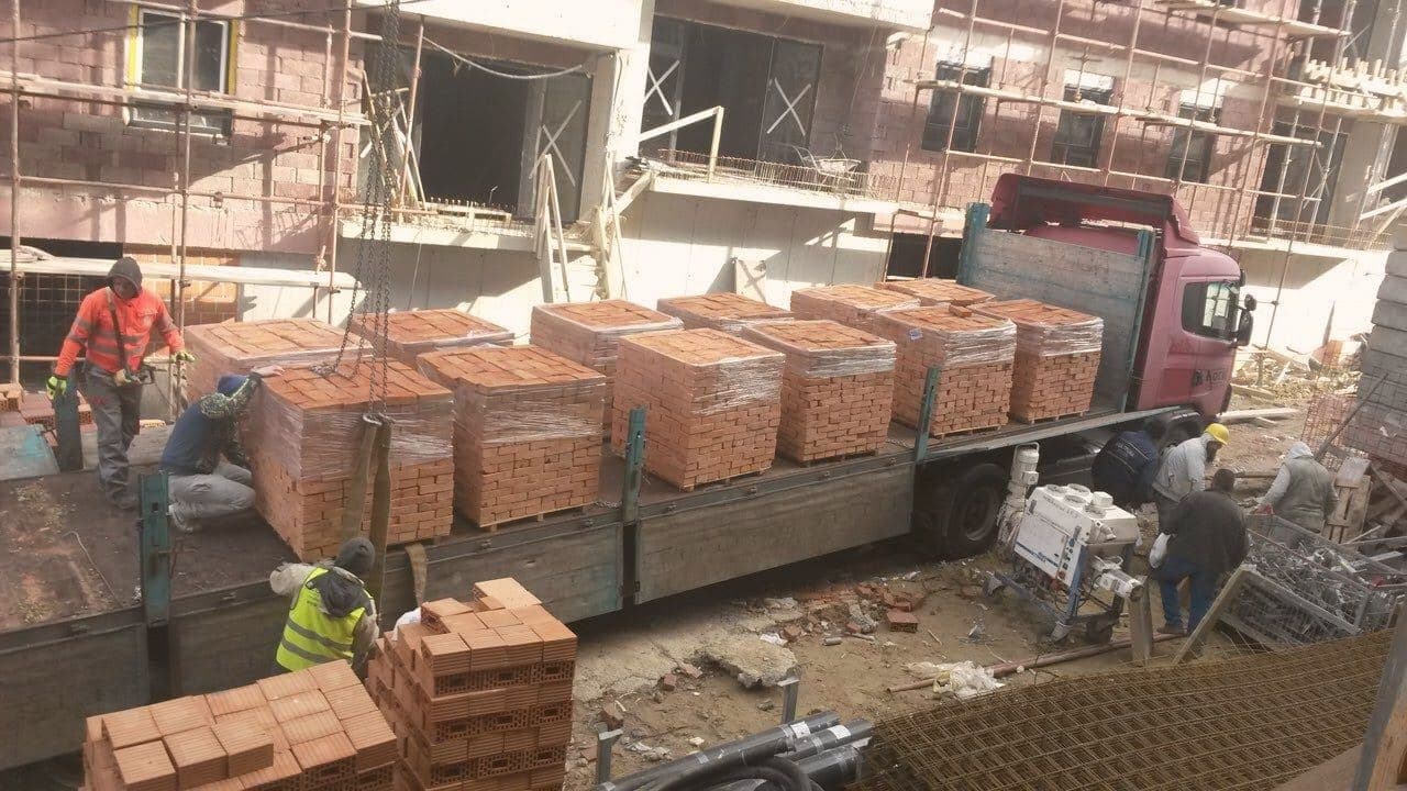 Palete pune opeke na gradilištu